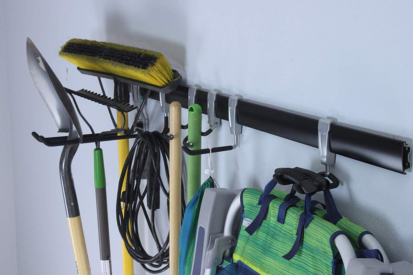 wall rail storage with shovel, broom, and chair