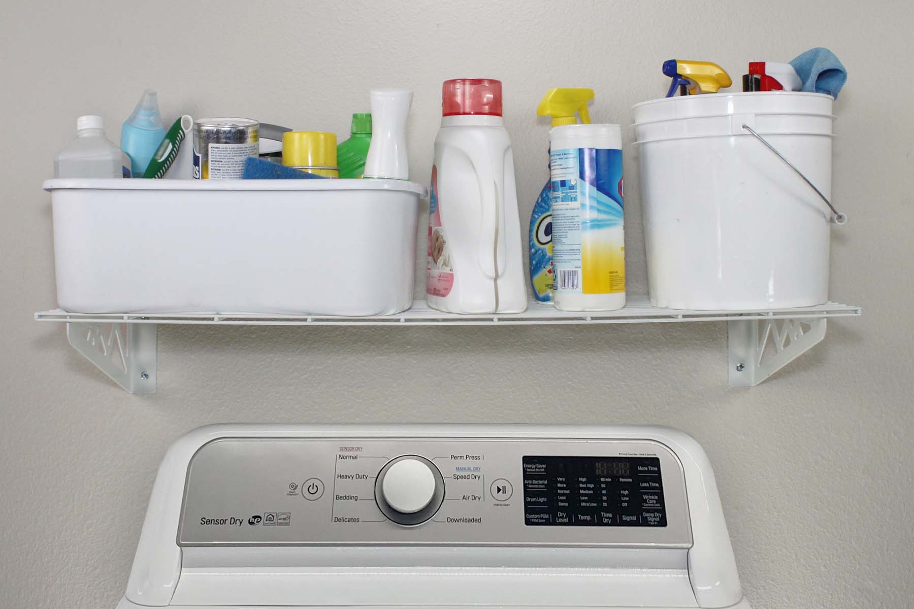 white wall shelf with detergent above washing machine