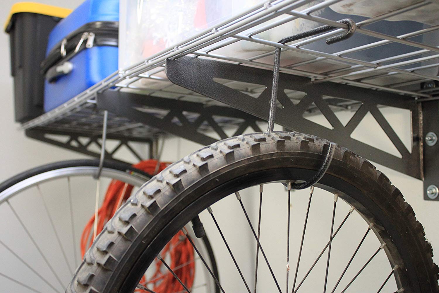 close up of bicycle hanging from wall shelf hook